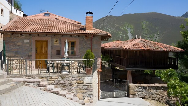 A stone building with a tiled roof, a wooden balcony, and a stone staircase leading to the entrance. - Country House 'Casa de Aldea La Quintana' with Mountain Views (Las Viñas)