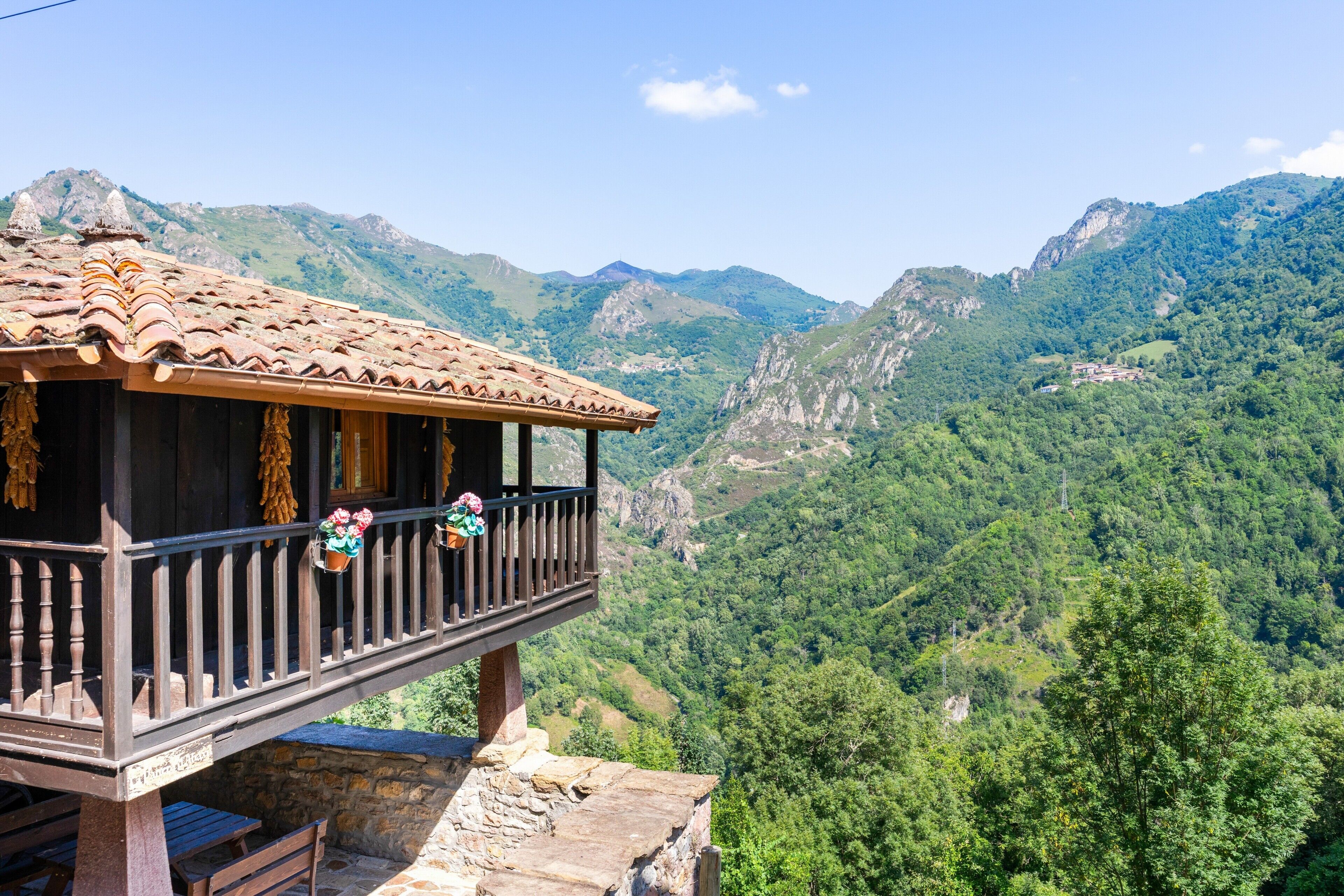 Un balcon en bois offrant une vue sur un paysage montagneux.
