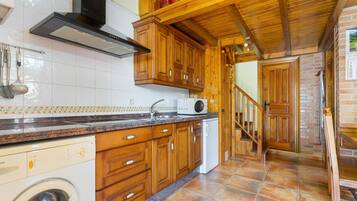 A kitchen with wooden cabinets, a built-in oven, and a washing machine.