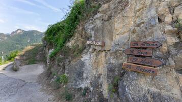 A rocky path with directional signs pointing to various destinations.