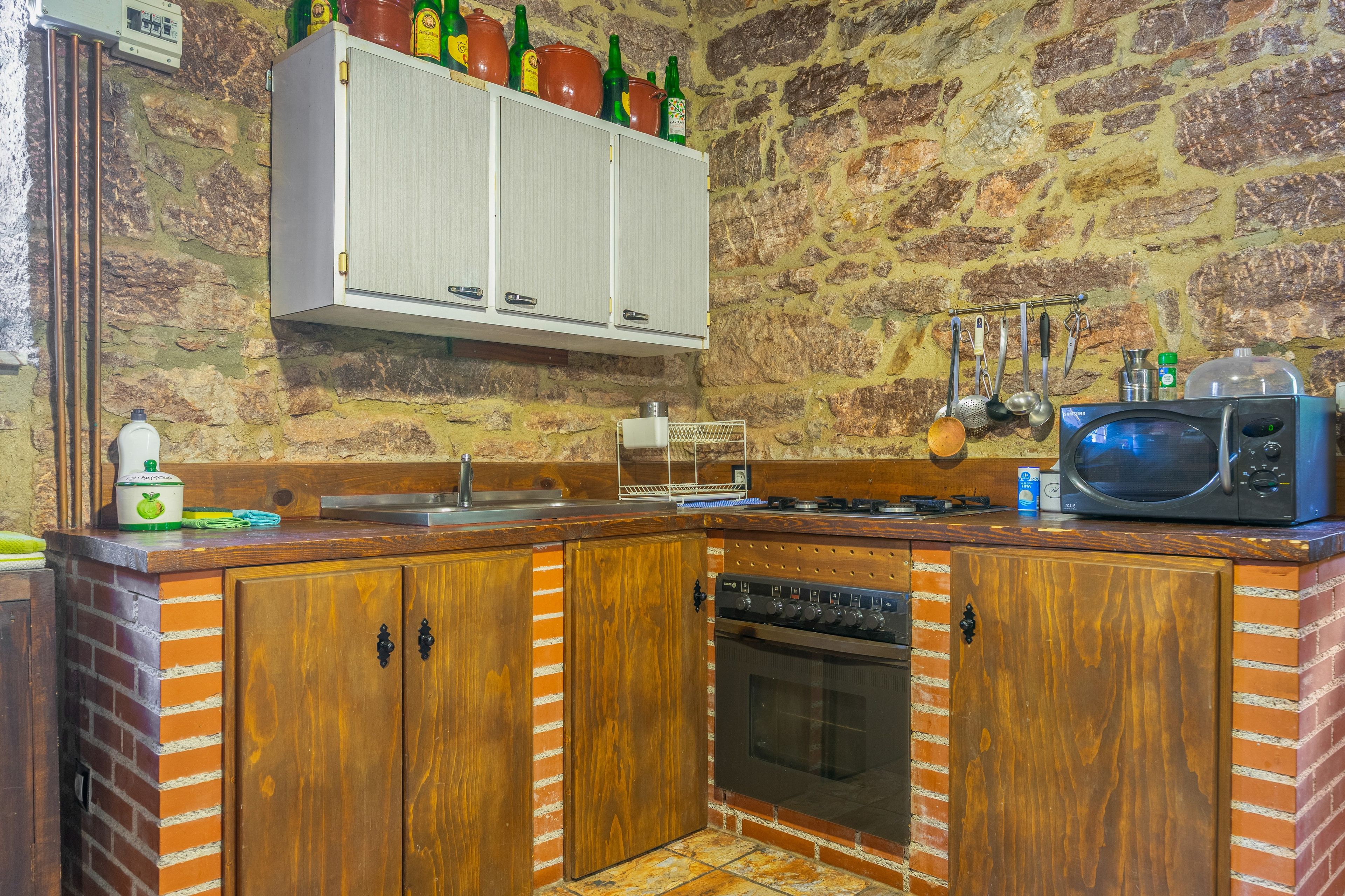 A kitchen with wooden cabinets, a microwave, and a stove.