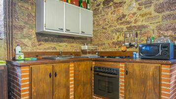 A kitchen with wooden cabinets, a microwave, and a stove.