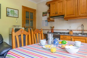 A kitchen with wooden cabinets, a striped tablecloth, and breakfast items.