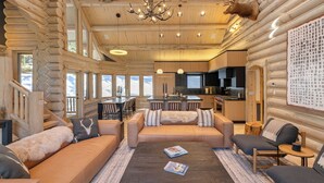 Ein Holzhaus-Interieur mit Wohnbereich, Sofa, Couchtisch und Küche.