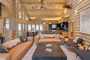Ein Holzhaus-Interieur mit Wohnbereich, Sofa, Couchtisch und Küche.