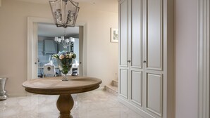 A marble-floored hallway with a round wooden table, a chandelier, and a white cabinet. - Villa Cesara - Casa del Sole (Vabriga)