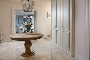 A marble-floored hallway with a round wooden table, a chandelier, and a white cabinet. - Villa Cesara - Casa del Sole (Vabriga)
