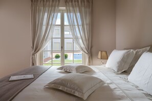A hotel room with a bed, curtains, a lamp, and a view of the outside. - Villa Cesara - Casa del Sole (Vabriga)