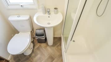 Un baño con inodoro, lavabo y ducha.