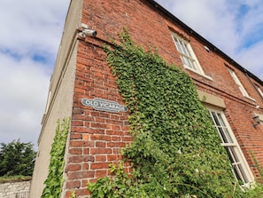 Un bâtiment en briques sur lequel on peut lire l’inscription « Ancien presbytère ».