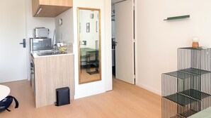 Eine kleine Küche mit einer Mikrowelle, einem Kühlschrank und einem Holzkorpus.