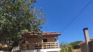 Un bâtiment à deux étages doté d’un balcon, d’un mur en pierre et d’un petit jardin.