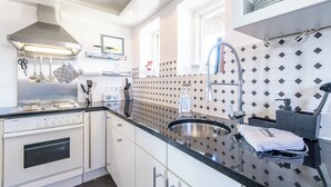Een moderne keuken met een roestvrijstalen fornuis, een spoelbak en een raam boven de aanrecht.