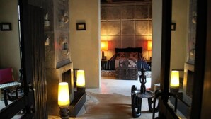 Een hotelkamer met een bed, bedlampen, een klein tafeltje en een spiegel.
