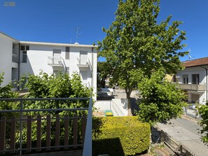 A residential building with balconies, a tree, and a clear blue sky. - Apartment 27 Steps From The Sea - New Life B&B (Cesenatico)