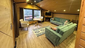 Una habitación acogedora con un sofá verde, una mesa blanca y una chimenea.