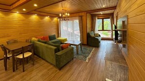 Un interior de madera con un sofá, una mesa de comedor y sillas.