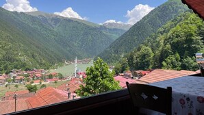 Paisaje montañoso con un pueblo, una iglesia y un lago.
