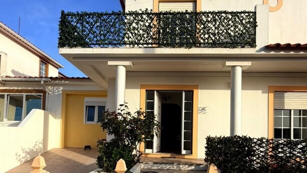 Un immeuble de deux étages doté d’un balcon, d’une entrée sécurisée par un portail et d’une enseigne indiquant « VIO’S HOME 11 ».