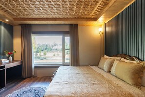 A bedroom with a large bed, a window with curtains, a desk with a vase of flowers, and a patterned ceiling. - Khwab Villa A Luxury Stay (Gund)