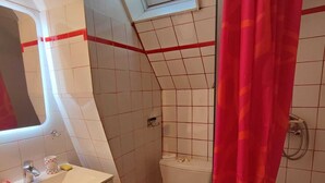 Ein Badezimmer mit einem weißen Waschbecken, einer roten Toilette und einer Duschvorhang.