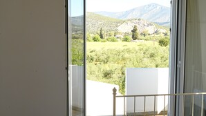A balcony with a view of a mountainous landscape. - Apartment 'The Rustic Archontiko' with Sea View (Kranidi)
