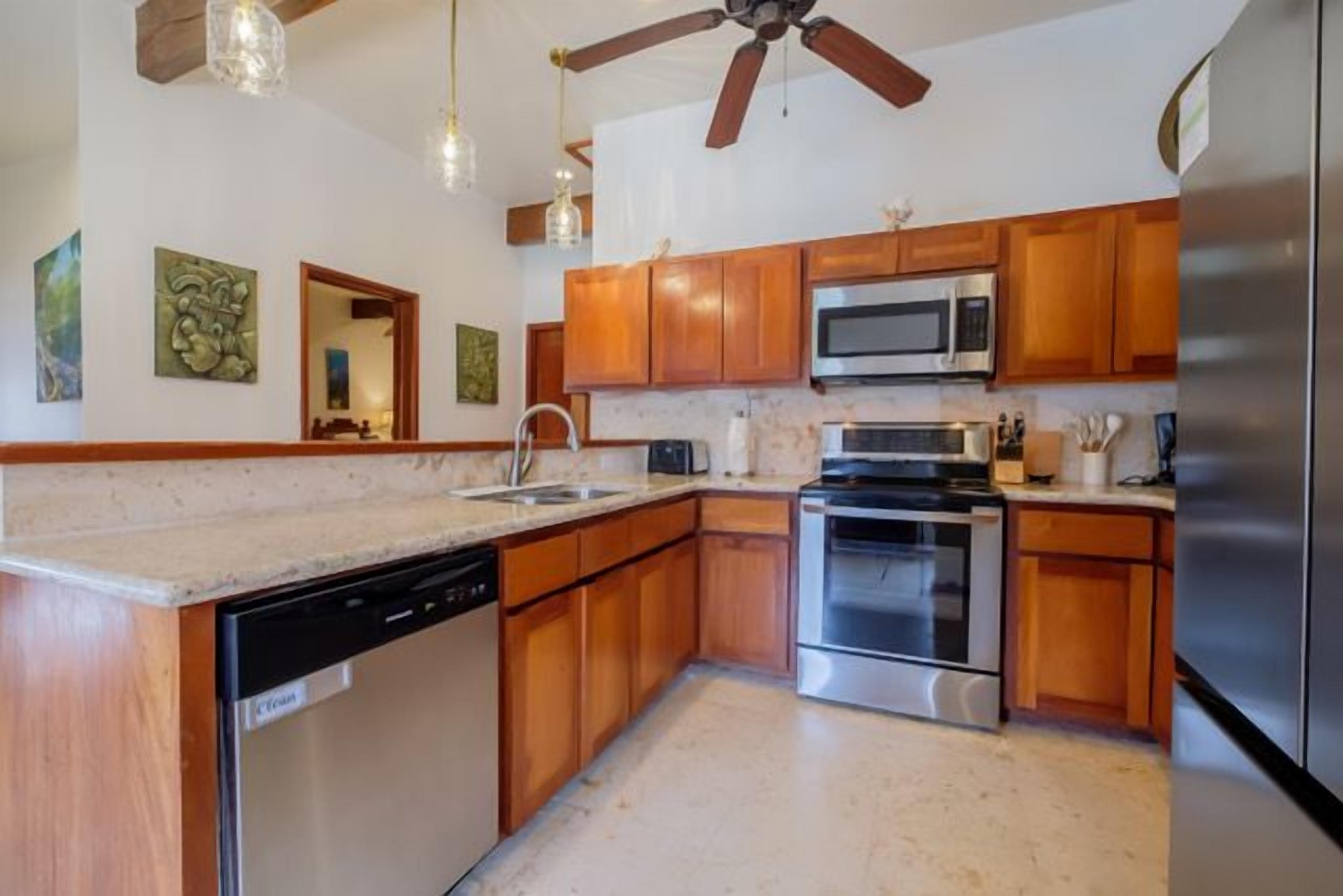 A kitchen with wooden cabinets, stainless steel appliances, and a dishwasher.