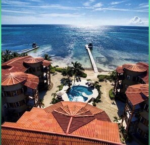 Ein Resort mit mehreren Gebäuden, einem Swimmingpool und einer an das Meer reichenden Pier.