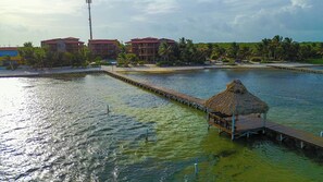 Ein Resort mit einer Bootsanlegestelle, einer strohgedeckten Hütte und mehreren Gebäuden mit roten Dächern.