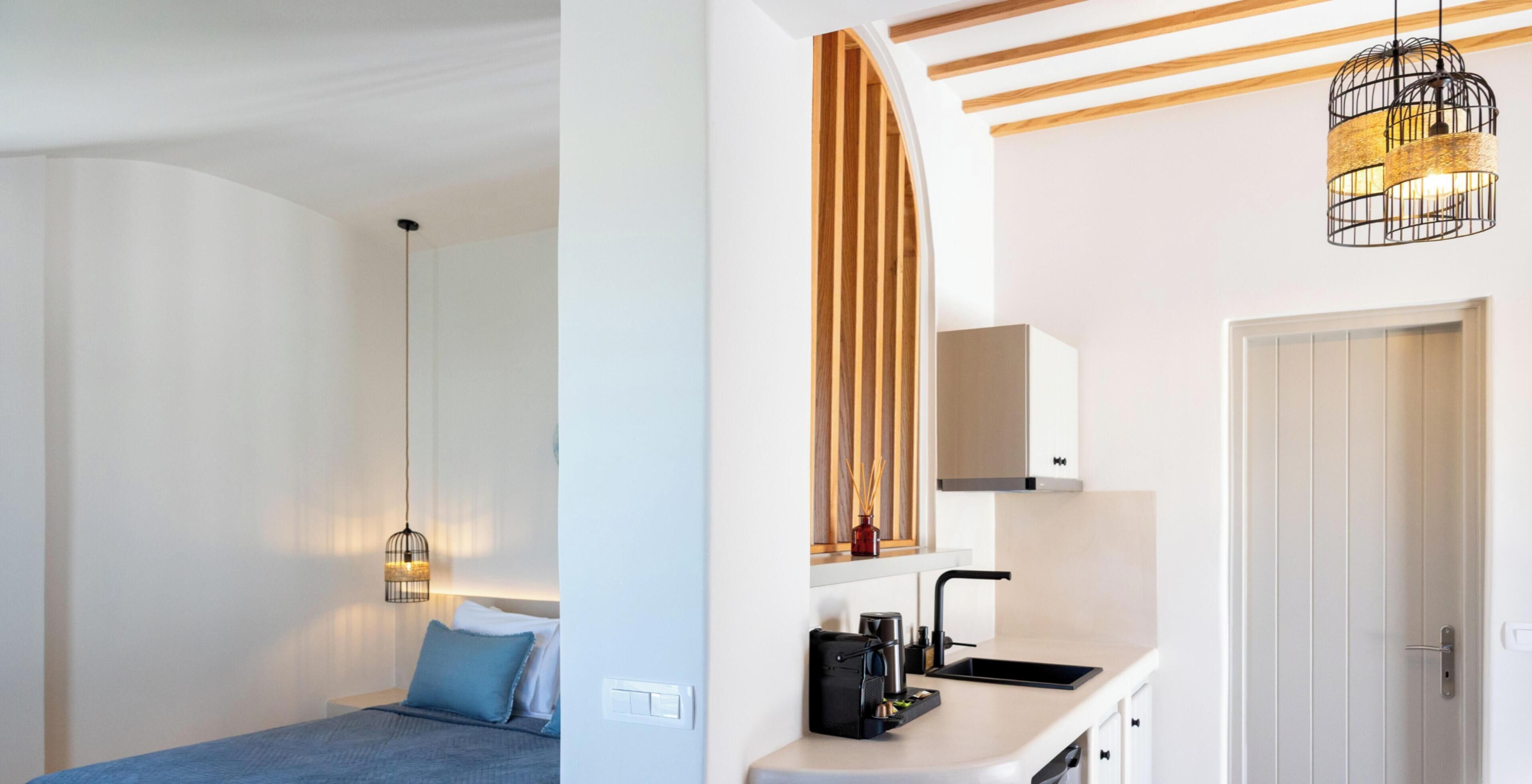 A modern hotel room with a bed, bedside table, and a hanging light fixture.