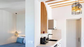 A modern hotel room with a bed, bedside table, and a hanging light fixture.