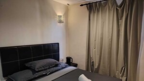 A hotel room with a bed, a nightstand, a lamp, and curtains. - The Ardens Hotel - Pandan Johor Bahru (Johor Bahru)