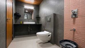 Une salle de bain moderne équipée de toilettes, d’un lavabo et d’une douche.
