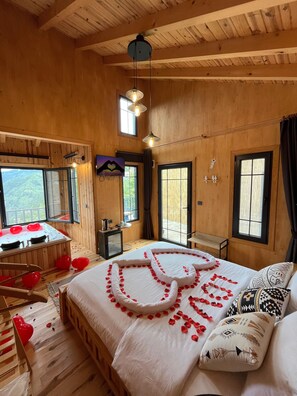 Una habitación de madera con una cama, una mesita y una ventana.