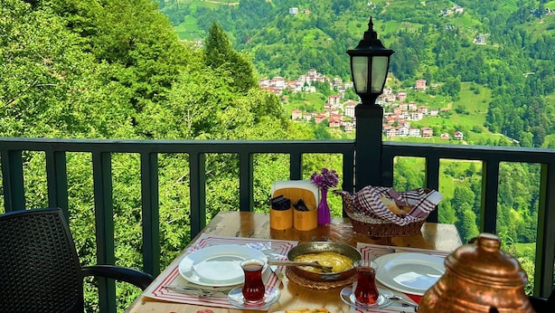 A table set for a meal with a scenic mountain view in the background.