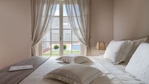A hotel room with a bed, curtains, a lamp, and a view of the outside. - Villa Cesara - Casa del Sole (Tar-Vabriga)