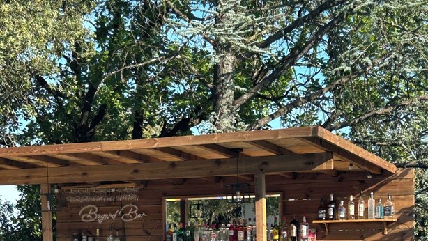 A wooden bar with a pool in the foreground. - The Villa des OLiviers and its superb swimming pool (Bagard)