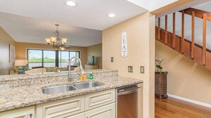 A kitchen with granite countertops, a stainless steel sink, and a dishwasher. - First-floor, snowbird-friendly townhouse w/ shared pool, WiFi, central AC, & W/D (Bokeelia)
