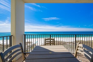 En balkon med udsigt over strand og hav.