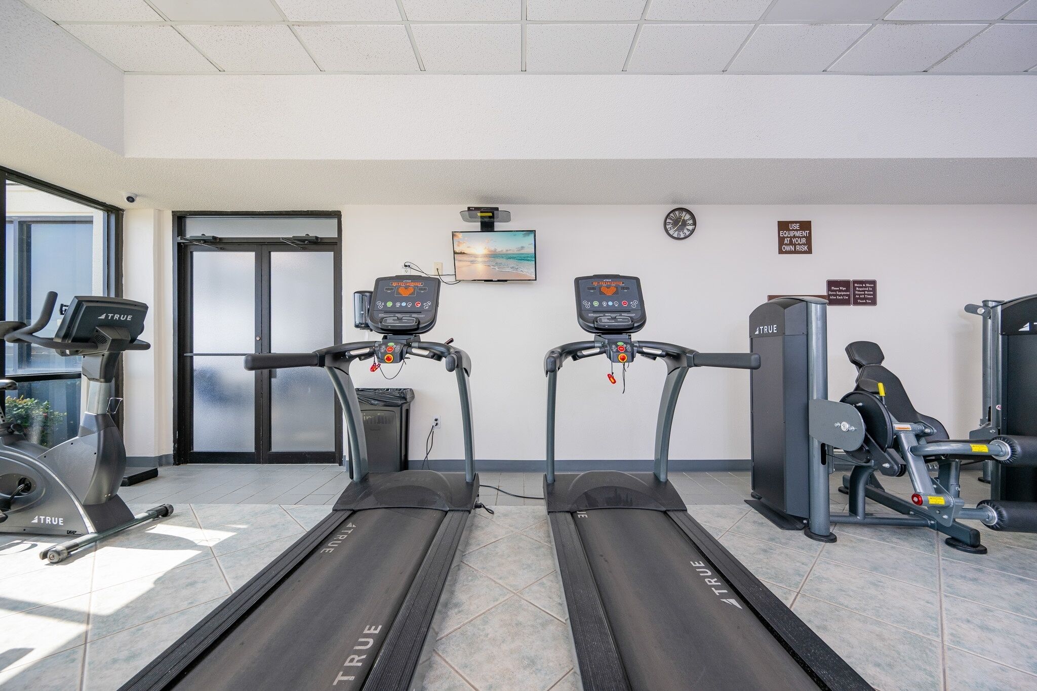 A gym with treadmills, a stationary bike, and weight machines.