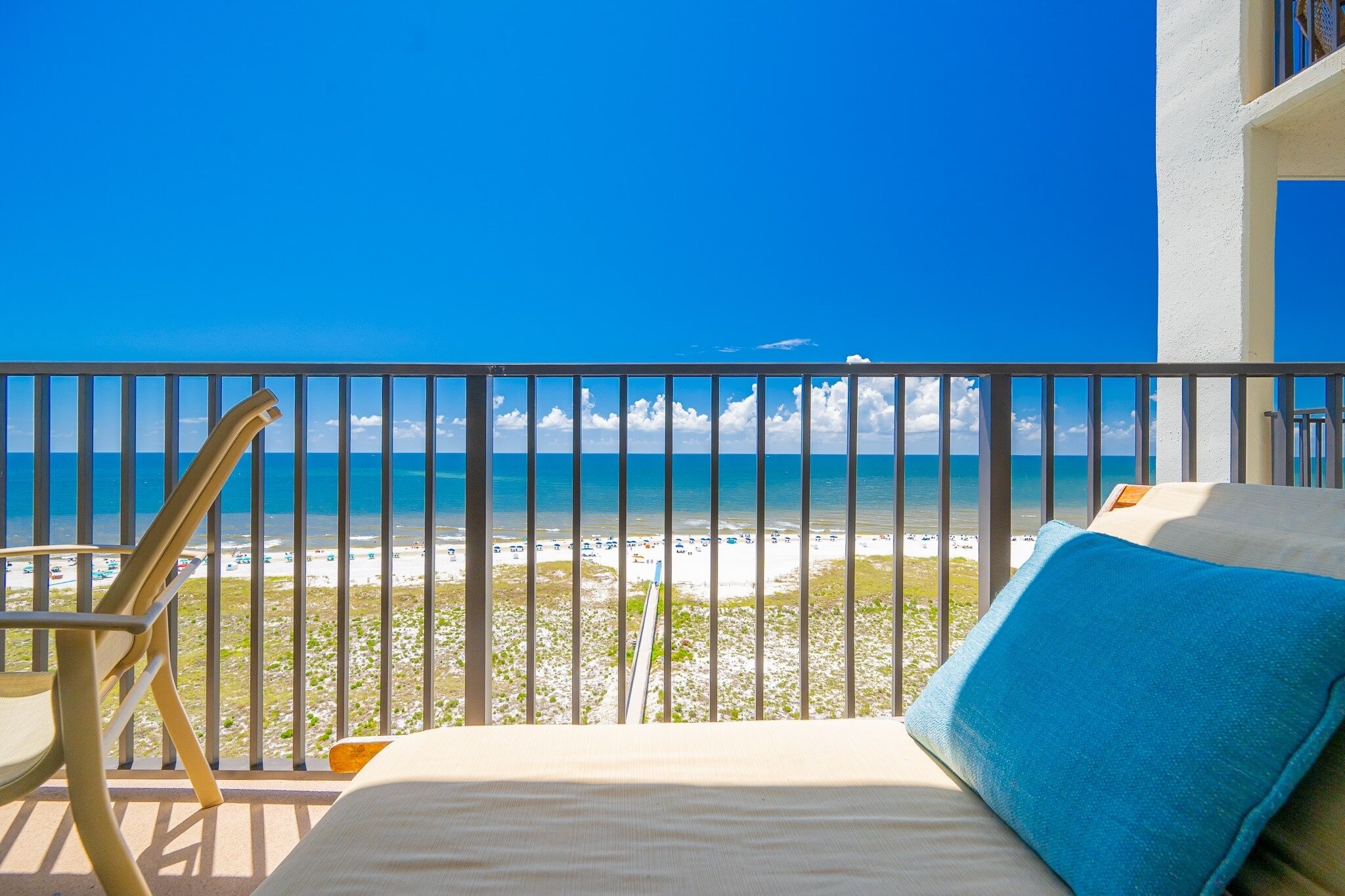 A balcony with a view of a beach and ocean.