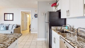 A kitchen with a refrigerator, sink, and countertop. - Panoramic water views, pool, private beach, AC, WIFI and close to Gulf beaches (Bonita Springs)