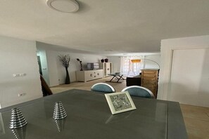 A dining area with a glass table, chairs, and a view into the kitchen. - Wonderful apartment in Triana, Purity (Sevilla)