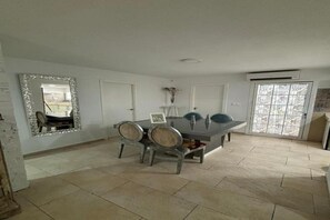 A dining area with a table and chairs, a mirror, and a door with a window. - Wonderful apartment in Triana, Purity (Sevilla)