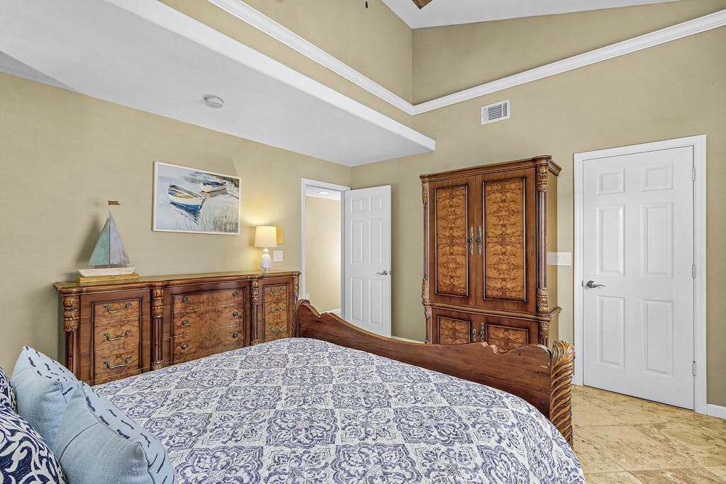 Une chambre à coucher avec un lit, une commode et des portes.
