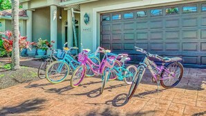 Un garaje residencial con una placa de matrícula, un camino de entrada y una fila de bicicletas.
