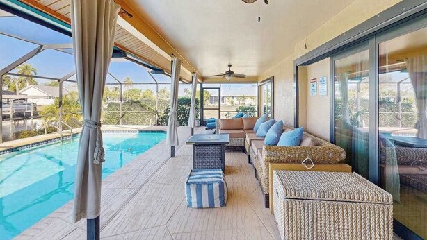 Un espace piscine extérieur avec des sièges et un ventilateur de plafond.