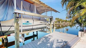 Un bateau nommé « Rebates » a accosté à un quai doté d’une zone abritée et d’une terrasse en bois.