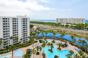 A hotel with a pool, palm trees, and a view of the ocean. - 2BR~ Lagoon Pool~ Palms of Destin 21211 (Destin)