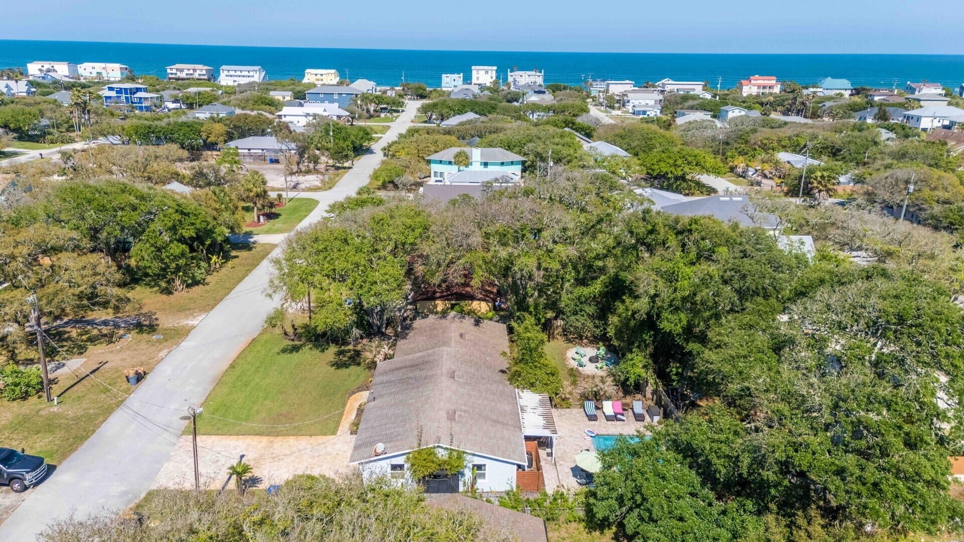 A residential area with houses, a swimming pool, and a clear view of the ocean.